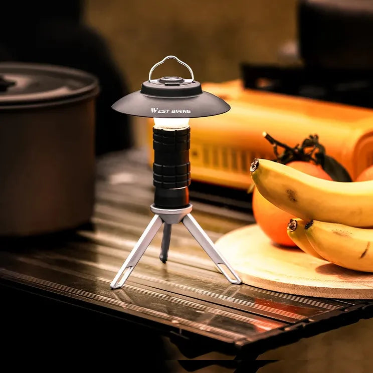 3-in-1 multifunction camping light used as a lantern on a table with folding tripod