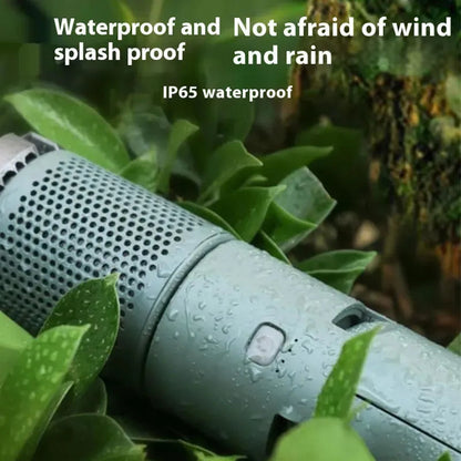 Close-up of telescopic camping lantern with water droplets lying among green leaves, showcasing its IP65 waterproof design and splash-proof capability.