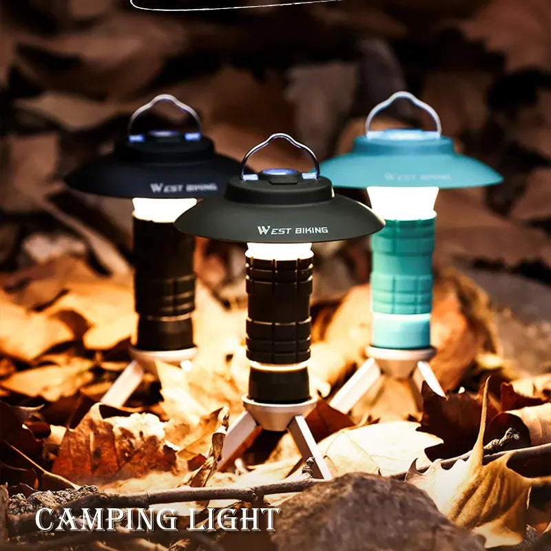Three multifunction camping lights in different colors on leaves outdoors