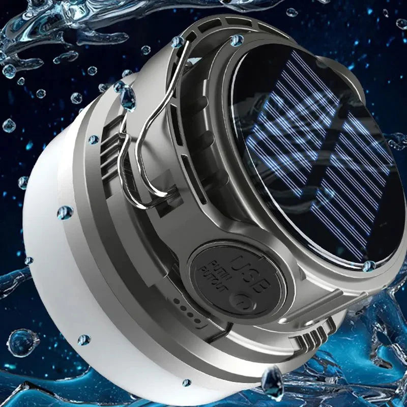 Close-up of the LED Adventure Light's solar panel top with water droplets and charging cable, demonstrating its waterproof design
